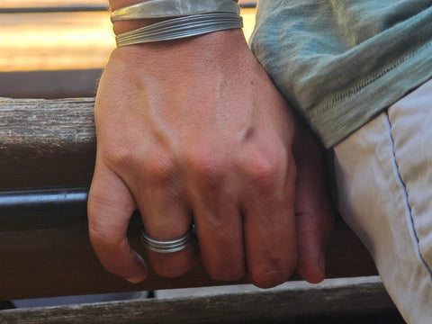 Ariadne men’s silver ring styled with handmade silver cuffs by Athenart Jewelry