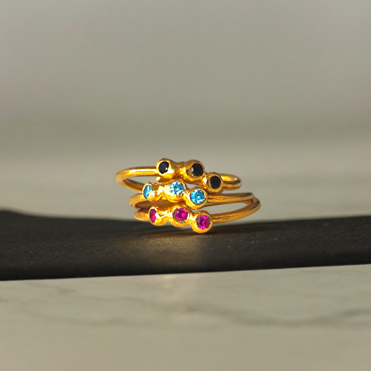 Adjustable Doty ring with red, blue, and black zircons
