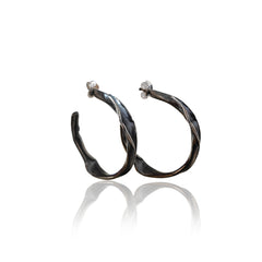 Twirl Peplos twisted hoop earrings in oxidized sterling silver on white background