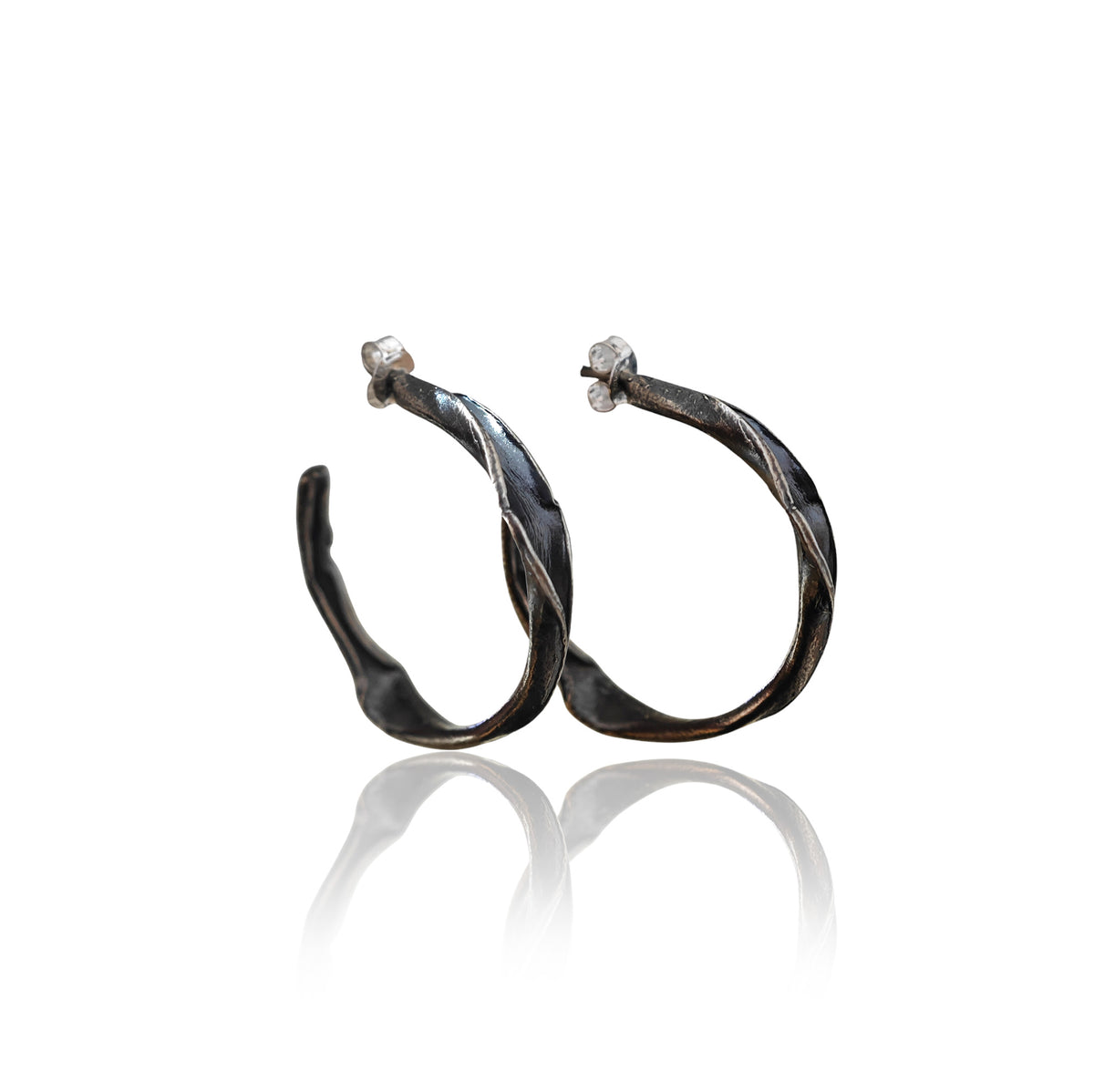 Twirl Peplos twisted hoop earrings in oxidized sterling silver on white background