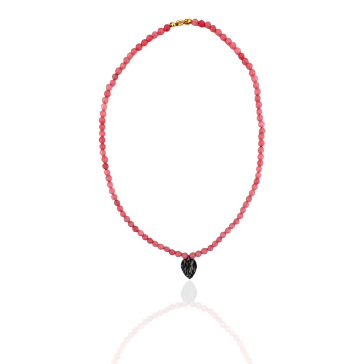 Necklace with red beads and a black heart-shaped pendant on a white background
