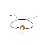 Moon Whisper gold-plated sterling silver moon bracelet worn on the wrist with black cord.