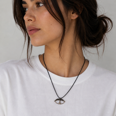 Model wearing minimal evil eye cord necklace by Athenart on white T-shirt