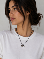 Model wearing minimal evil eye cord necklace by Athenart on white T-shirt