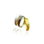 Two gold rings with textured bands on a white background