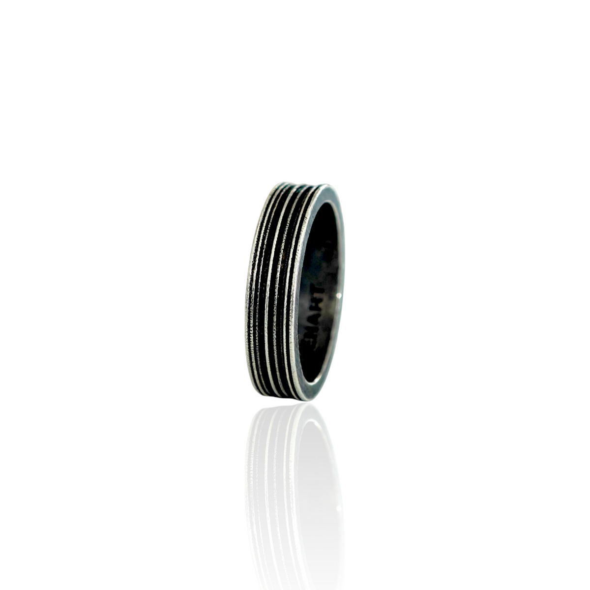 AN OXIDIZED silver-toned metal ring with a textured, ribbed exterior and a polished inner band, shown on a clean white background with a soft reflection below.