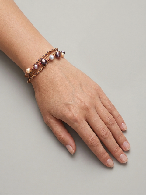 Handmade pearl cord bracelet with layered wax cords worn on wrist