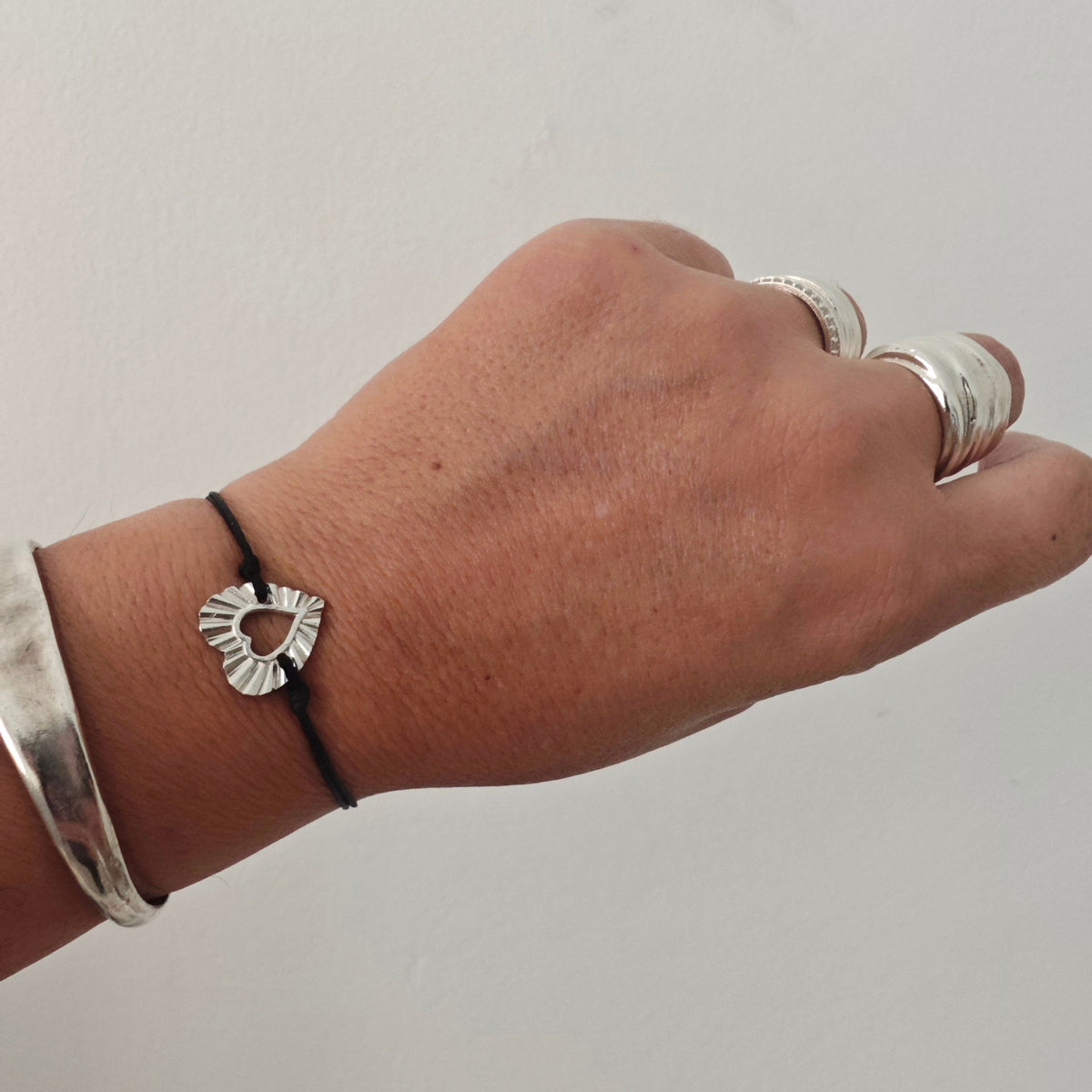 Handmade heart cord bracelet worn on wrist