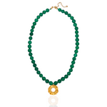 Green beaded necklace with a gold pendant on a white background