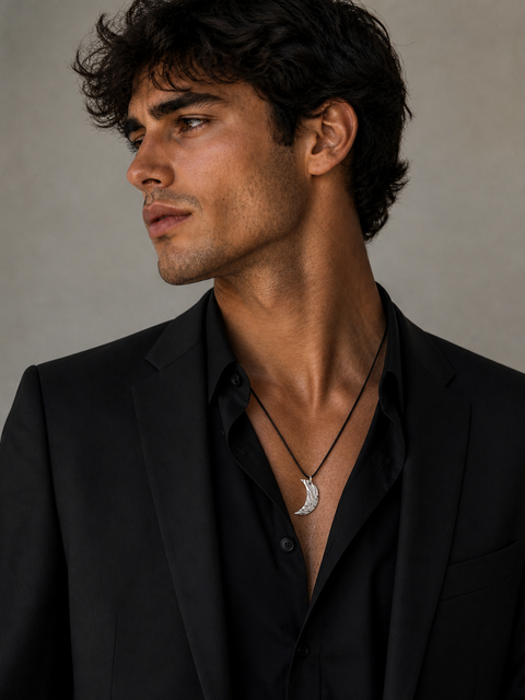 Handmade moon pendant necklace on black cord worn by male model in formal dressing 