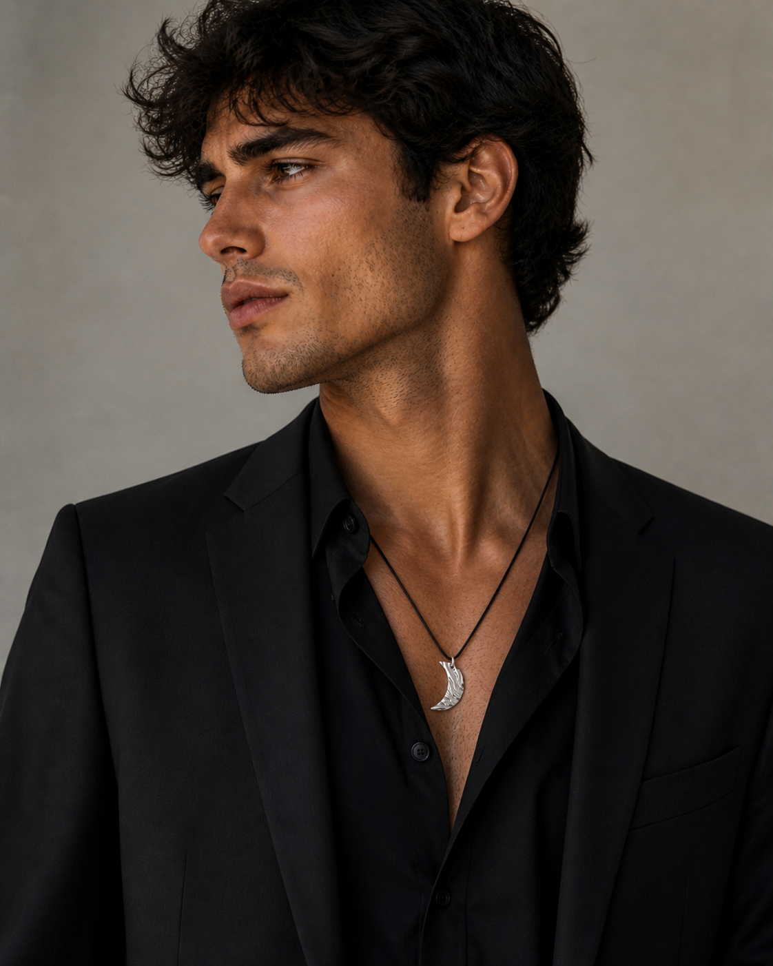 Handmade moon pendant necklace on black cord worn by male model in formal dressing 