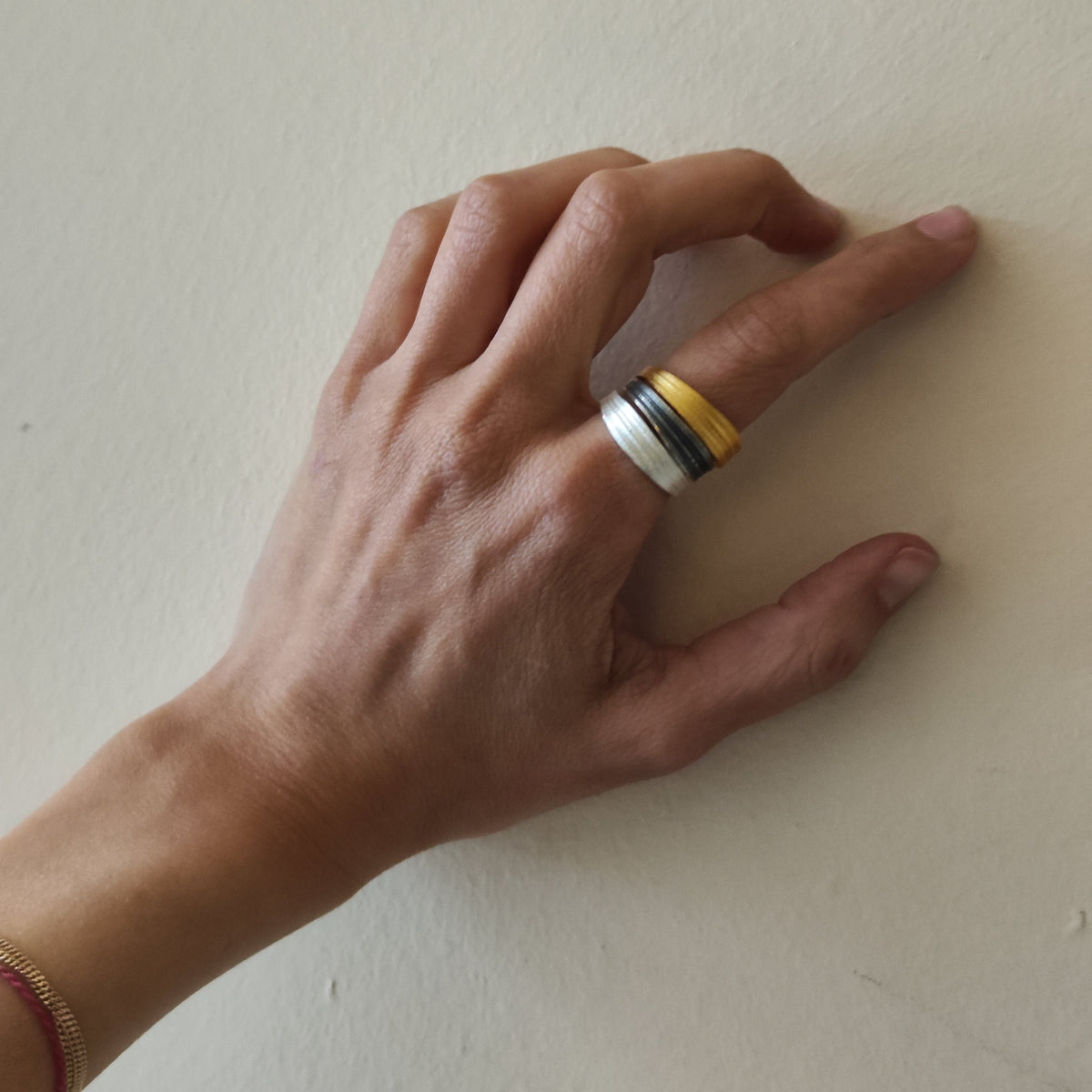 Hand wearing a ring on a plain background