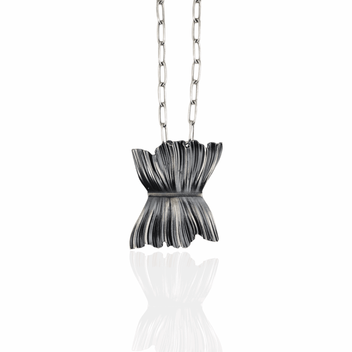 Agatha pendant close-up, pleated texture, oxidized silver finis
