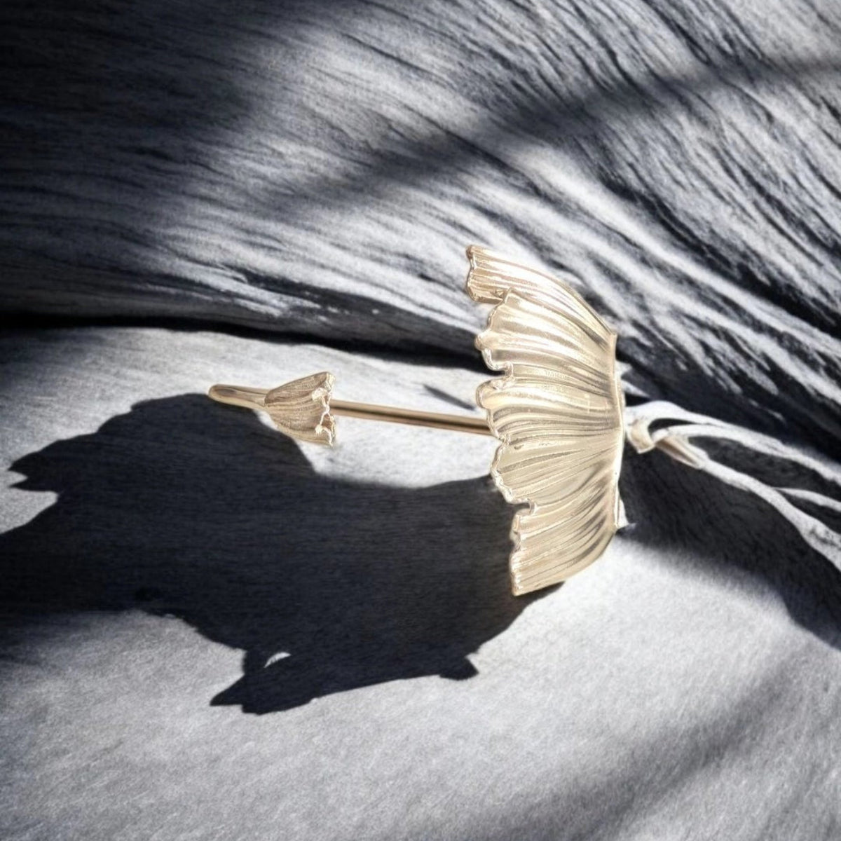 Peplos Aura Cuff Bracelet in gold plating on textured dark fabric background