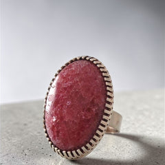 Close-up of one-of-a-kind pink rhodonite stone cabochon ring showing bezel detail and stone texture