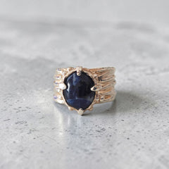 andmade sterling silver sodalite ring on grey stone surface with sculpted folds