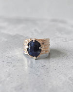 andmade sterling silver sodalite ring on grey stone surface with sculpted folds