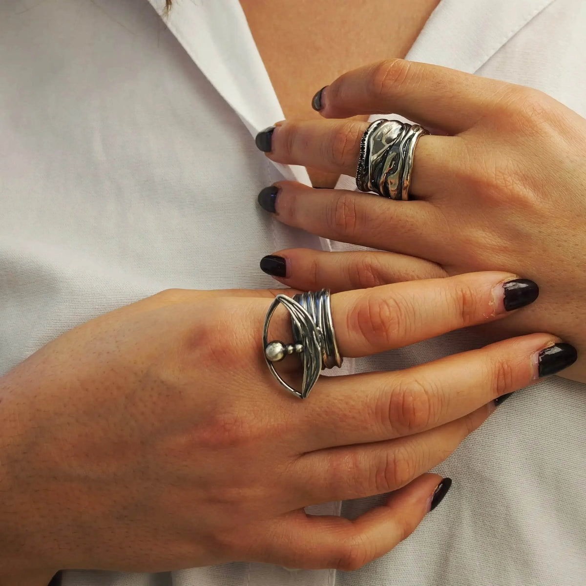 Model wearing Athenais Notos Ring with oxidized folds and zircon line, styled with other Athenart jewelry.