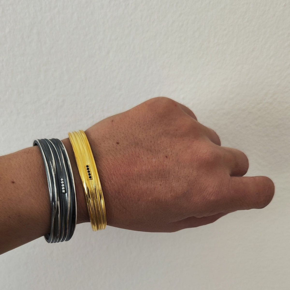Stacked cuffs: thin gold-plated and oxidized silver Peplos Flow bracelets with zircons on wrist – Athenart.”