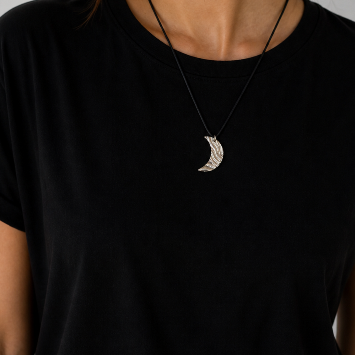 Moon cord necklace in silver worn by female model with black top