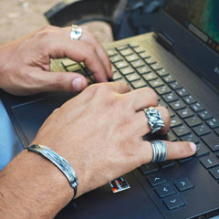 Men's silver rings , oxidized typing on laptop. Men's jewelry 
