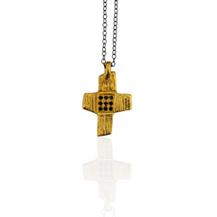 Gold cross pendant on a chain against a white background