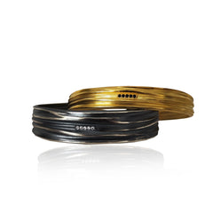 Two gold and black bracelets on a white background