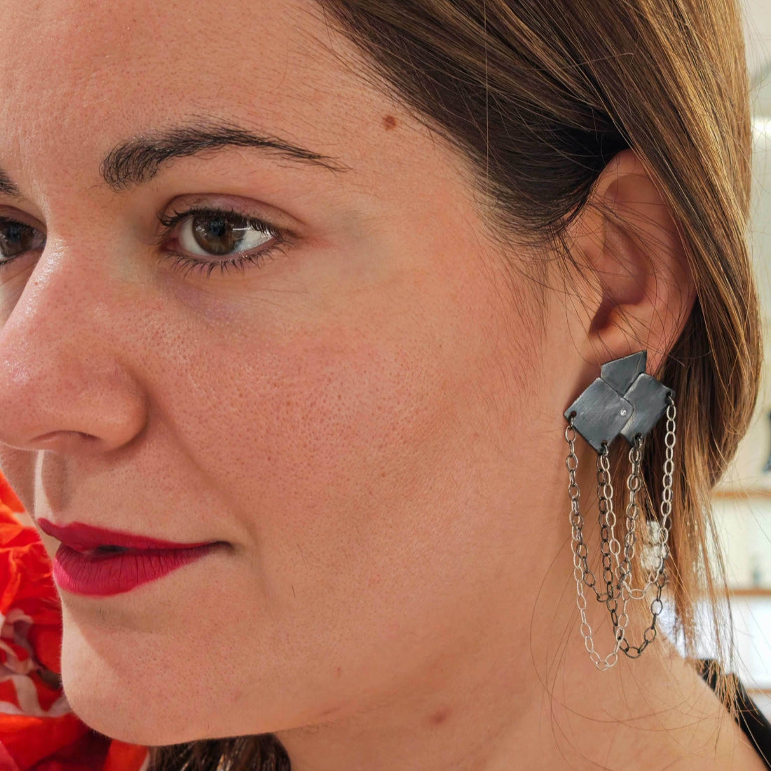 Model wearing Bouquet Rocker Earrings – bold geometric earrings with silver chains.
