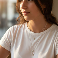 Galene fish necklace layered on model in silver with light blue zircon