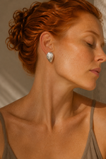 Editorial portrait of a ginger-haired model wearing Kelifos Pebble Stud Earrings.