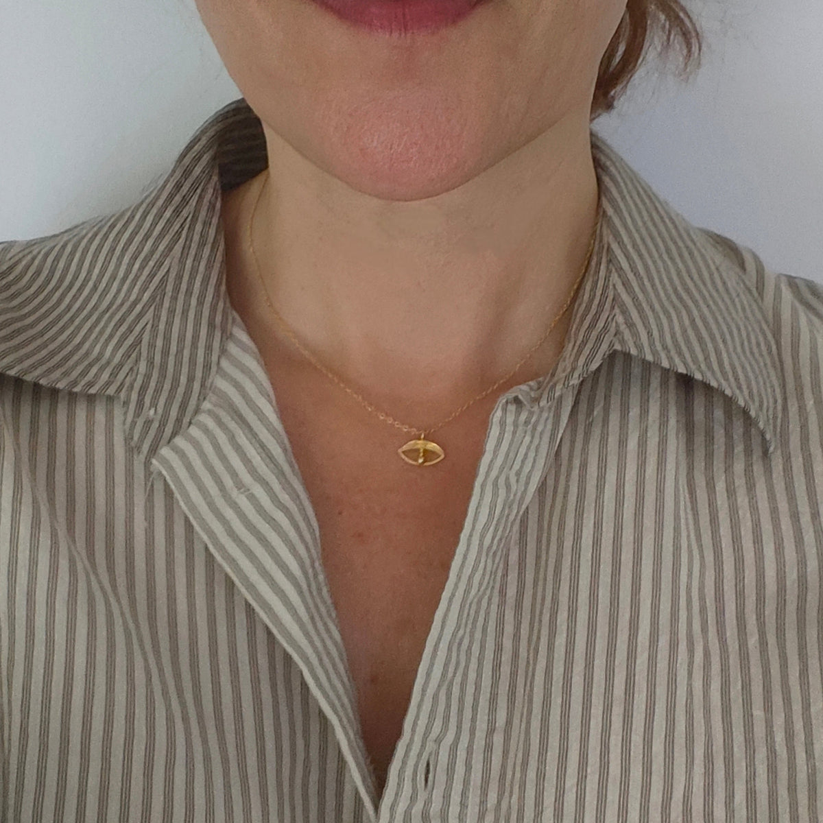 Argus tiny eye charm necklace worn – gold-plated on neckline – Athenart