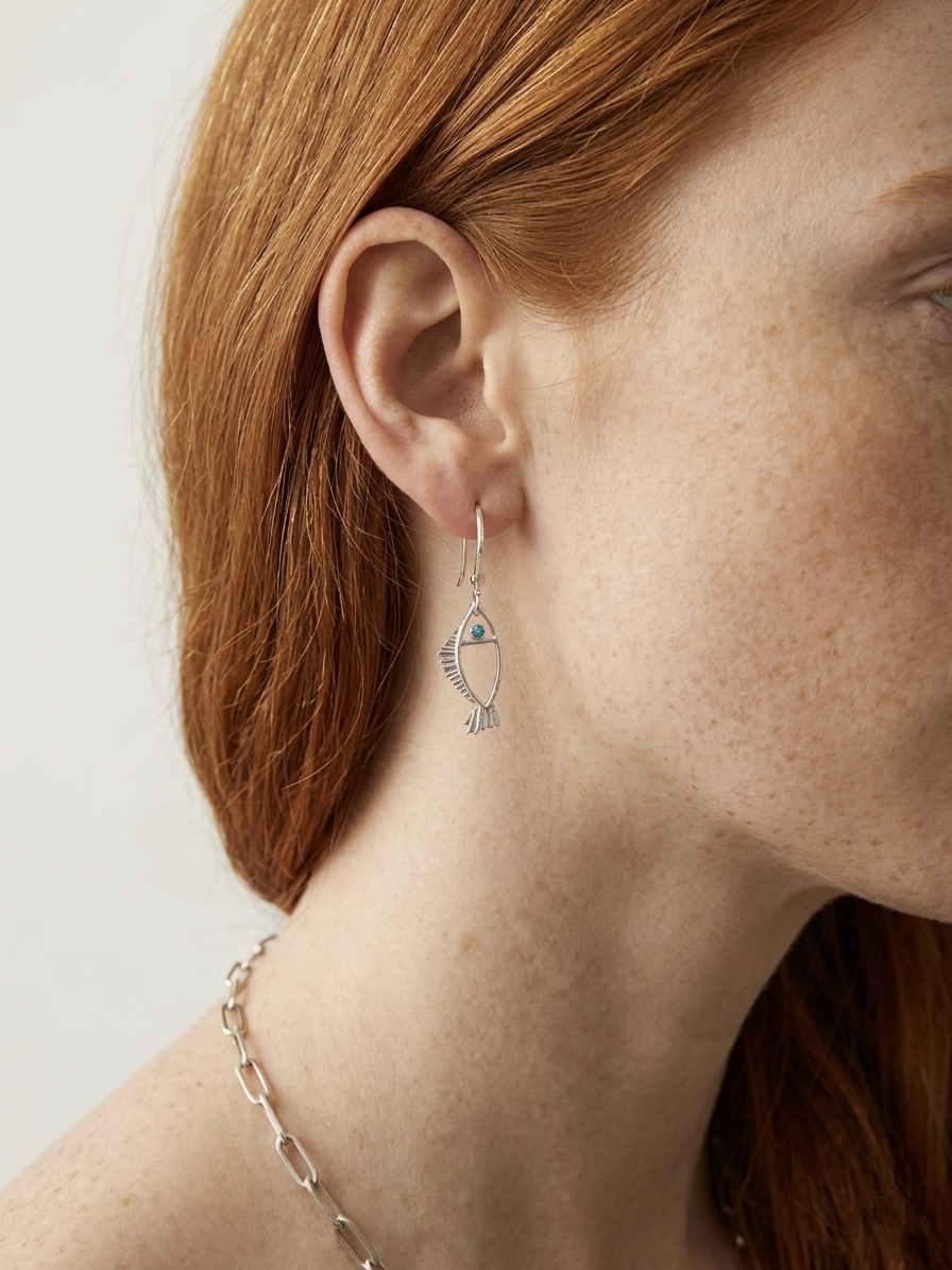 Minimal silver fish earrings with textured fins and zircon