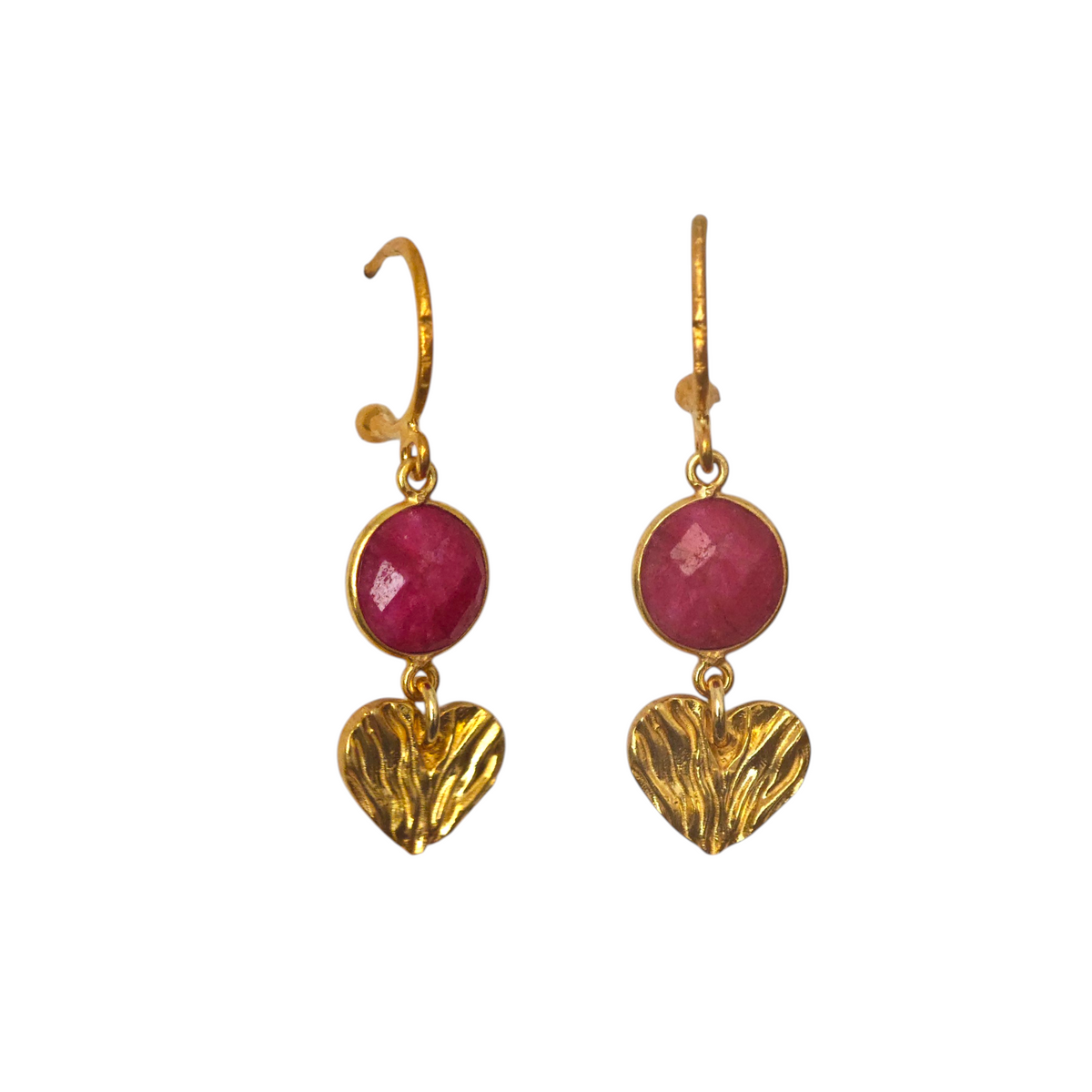 Gold heart earrings with ruby gemstones on a white background