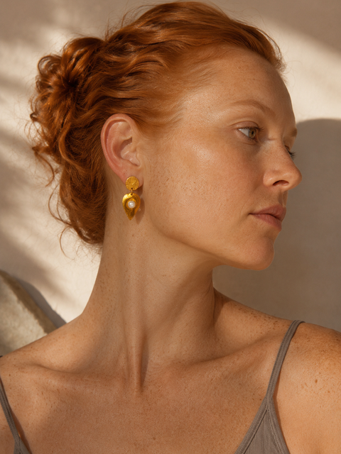 Editorial portrait of a ginger-haired model wearing Kelifos Pearl Stud Earrings.
