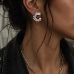 Close-up of Helios Eclipse silver stud earrings worn on ear, 2 cm contemporary Greek designer jewelry by Athenart.
