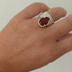 Naiás carnelian ring in sterling silver on hand, wide draped adjustable bandbackground