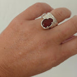 Naiás carnelian ring in sterling silver on hand, wide draped adjustable bandbackground