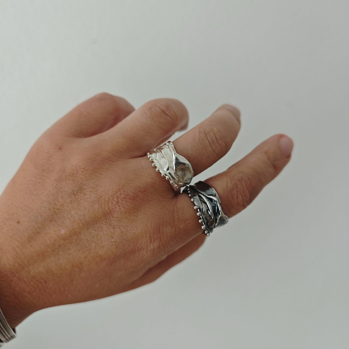 Athenais Hemline Ring worn on hand, highlighting sculpted folds and beaded hem