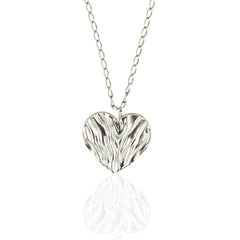 Silver heart-shaped pendant on a chain against a white background