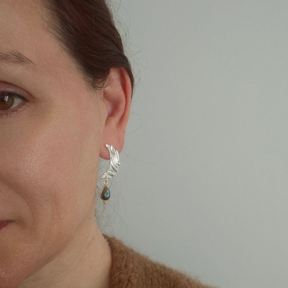 Labradorite moon earrings worn on ear, silver crescent with gemstone drop