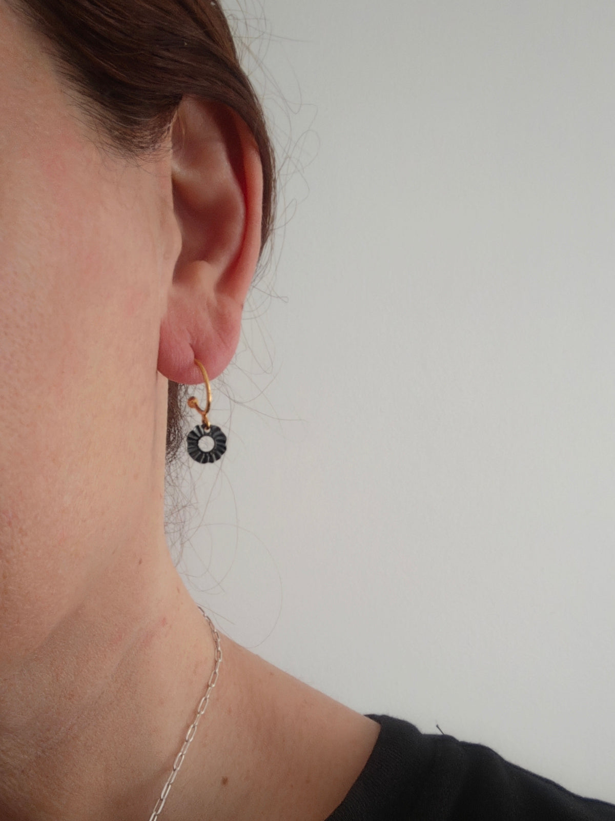 Helios mini hoop earrings worn on ear with gold and oxidized silver contrast