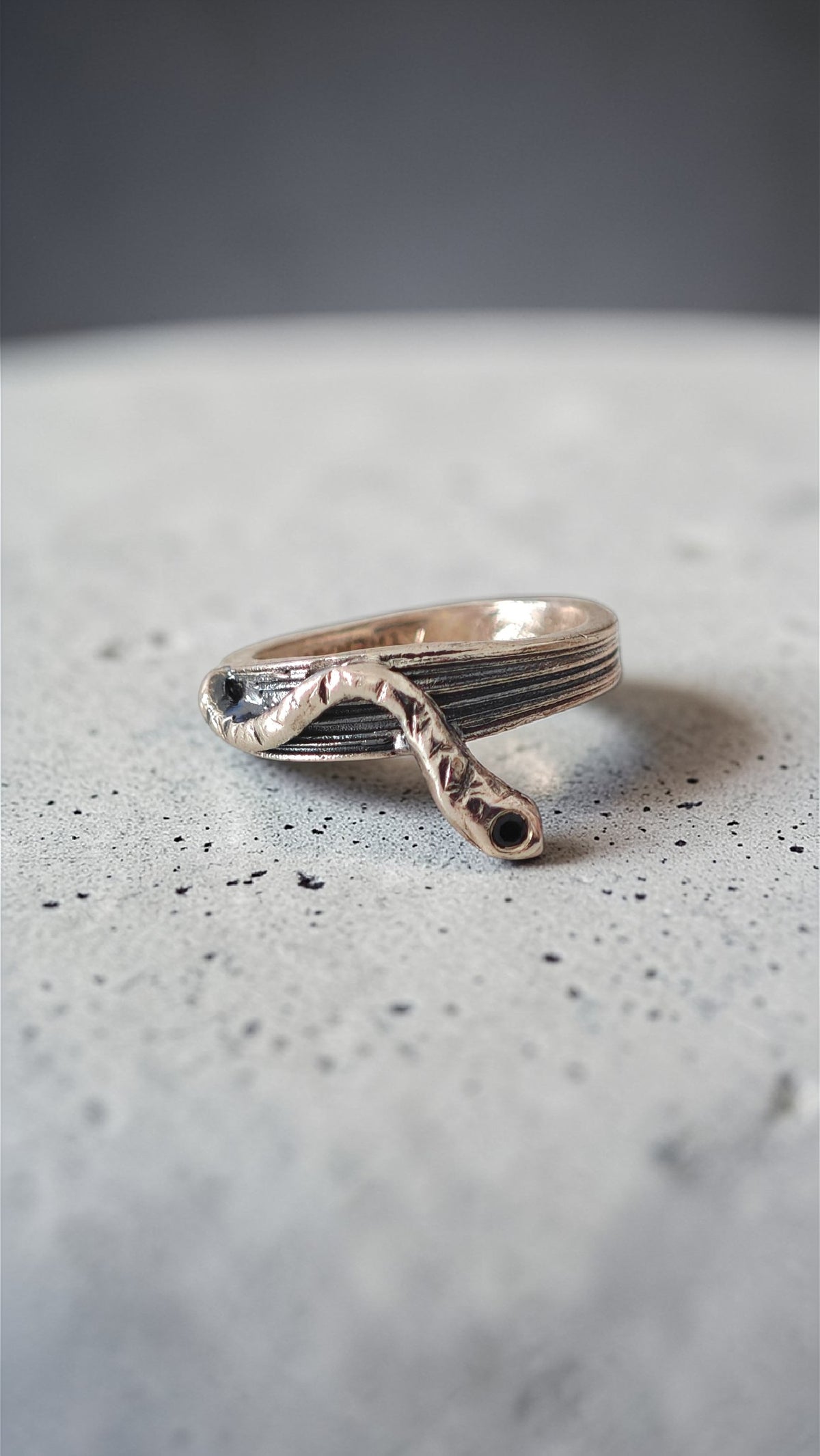 One-of-a-kind sterling silver serpent ring with oxidized details on grey surface, size 53