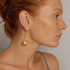 Ginger-haired model wearing Hidden Treasures Kelifos Pearl Earrings.