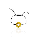 Black cord bracelet with a gold circular charm on a white background. Sun Lucky charm forever 