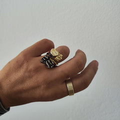 Hand wearing layered multiple gold and oxidized rings made   by Athenart in Athens