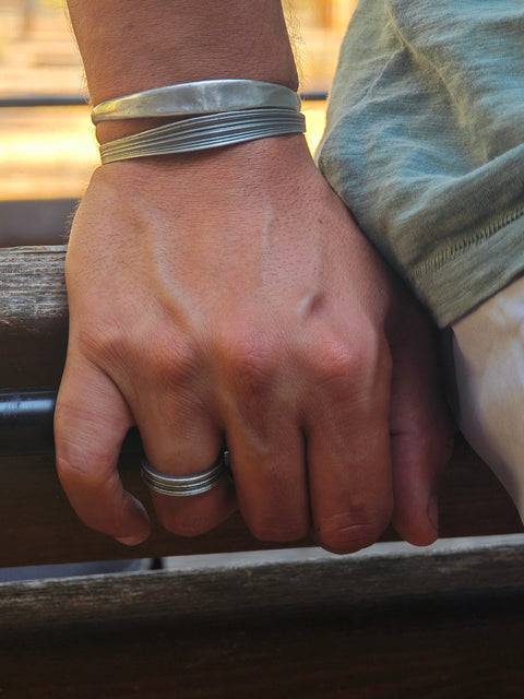 Ariadne men’s silver ring styled with handmade silver cuffs by Athenart Jewelry