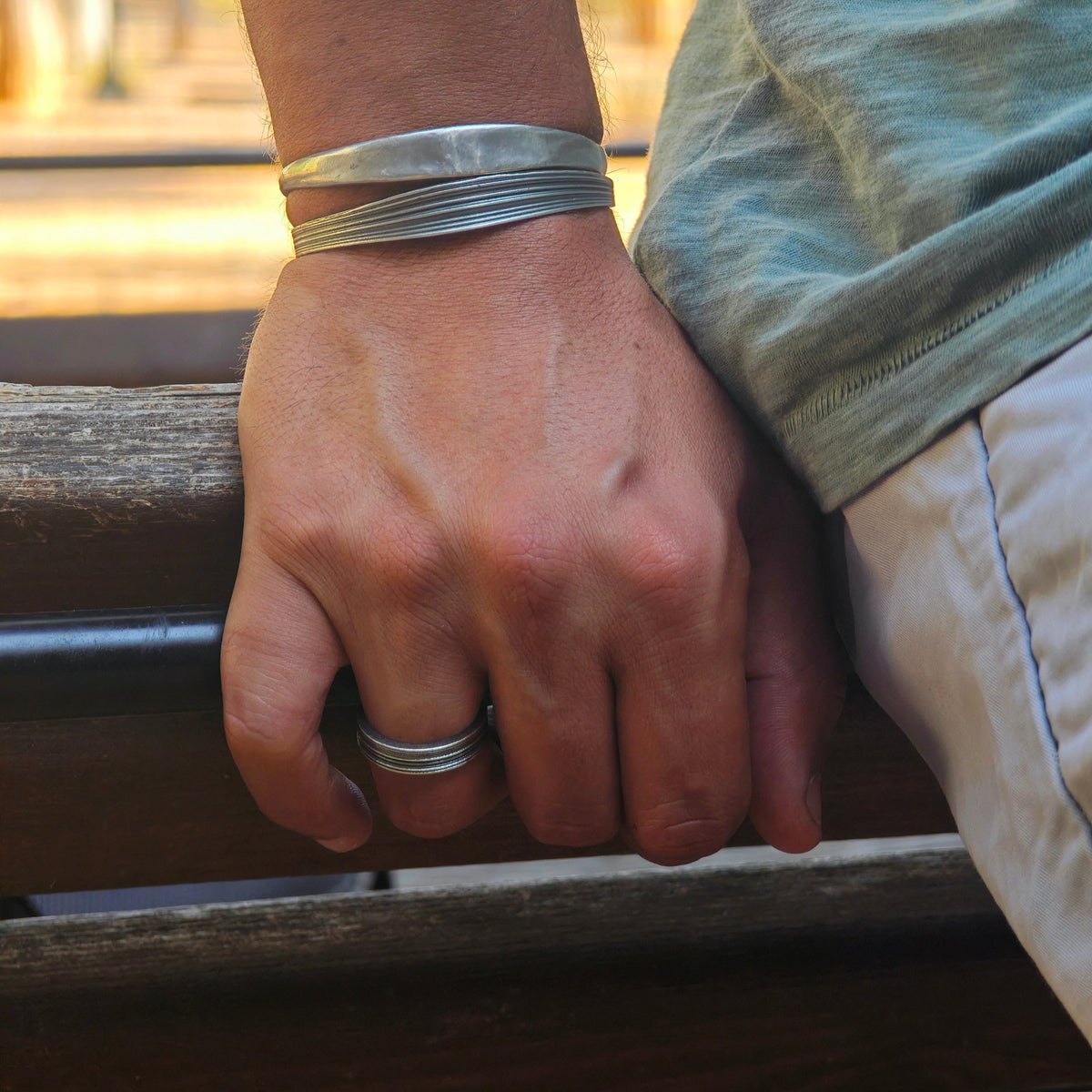 Ariadne men’s silver ring styled with handmade silver cuffs by Athenart Jewelry