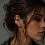 Close-up of a woman wearing a silver earring with a dark background