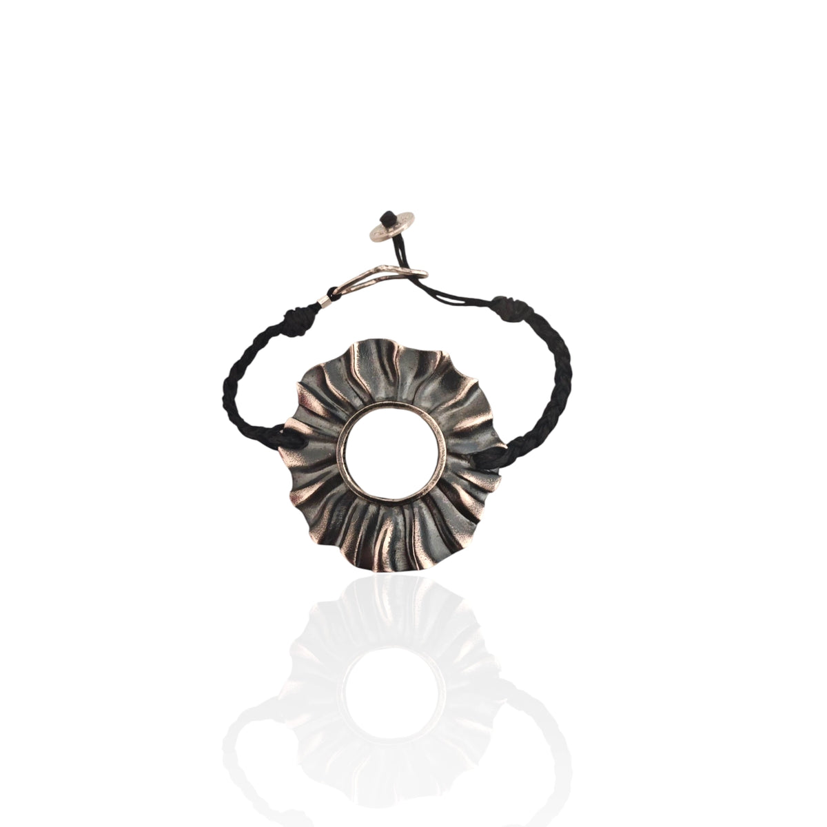 Helios oxidized silver sun bracelet (4×4 cm) on braided black cord, worn on wrist , Athenart Jewelry, handmade in Athens.”