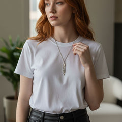 Model wearing Athenais Drapé Pendant in polished silver on long chain over white T-shirt, soft daylight